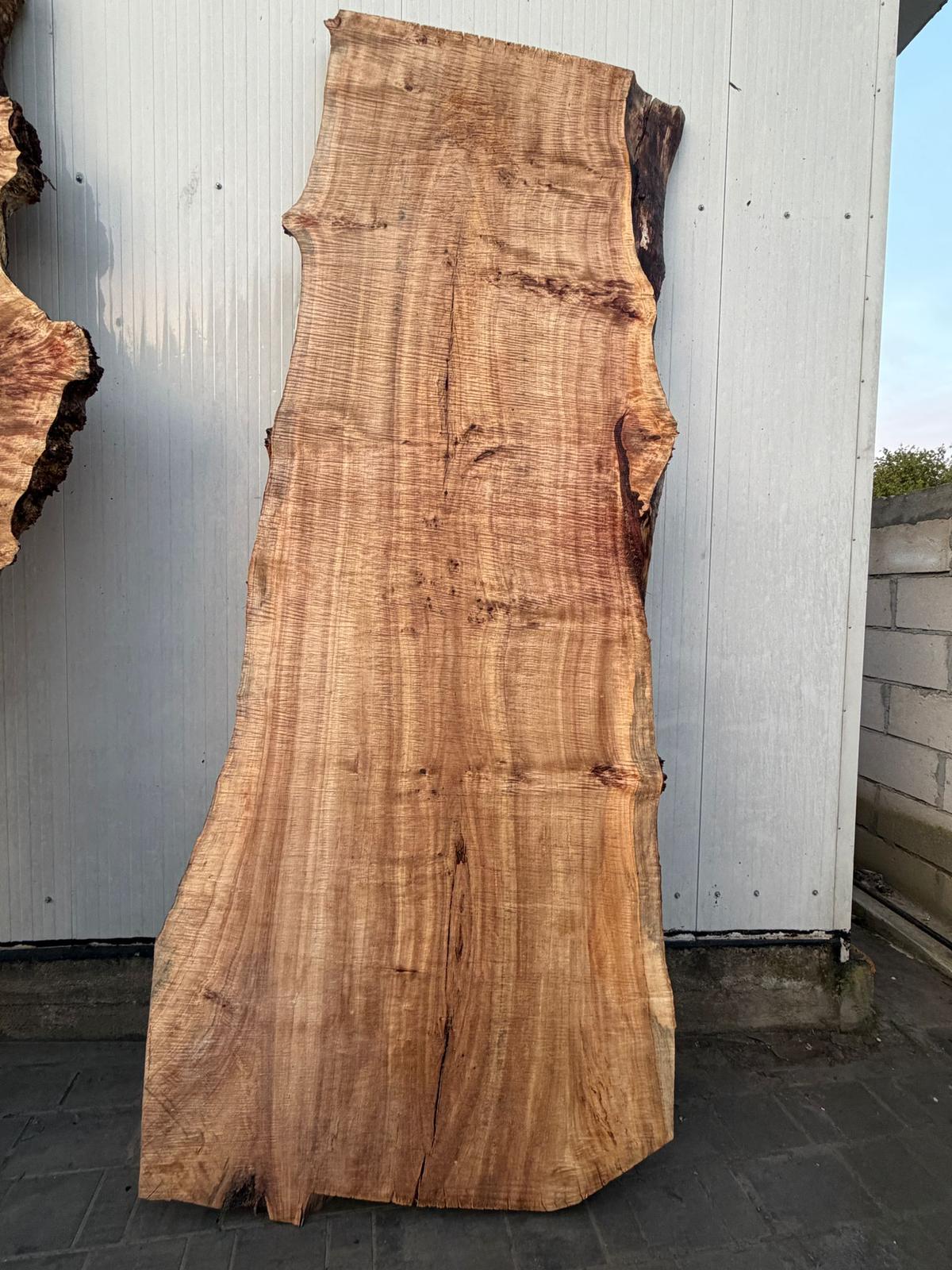 Blat înalt din lemn masiv cu figură creață și margine naturală, sprijinit de perete